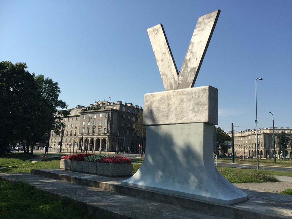 A monument by the socialist-realist buildings of Nowa Huta